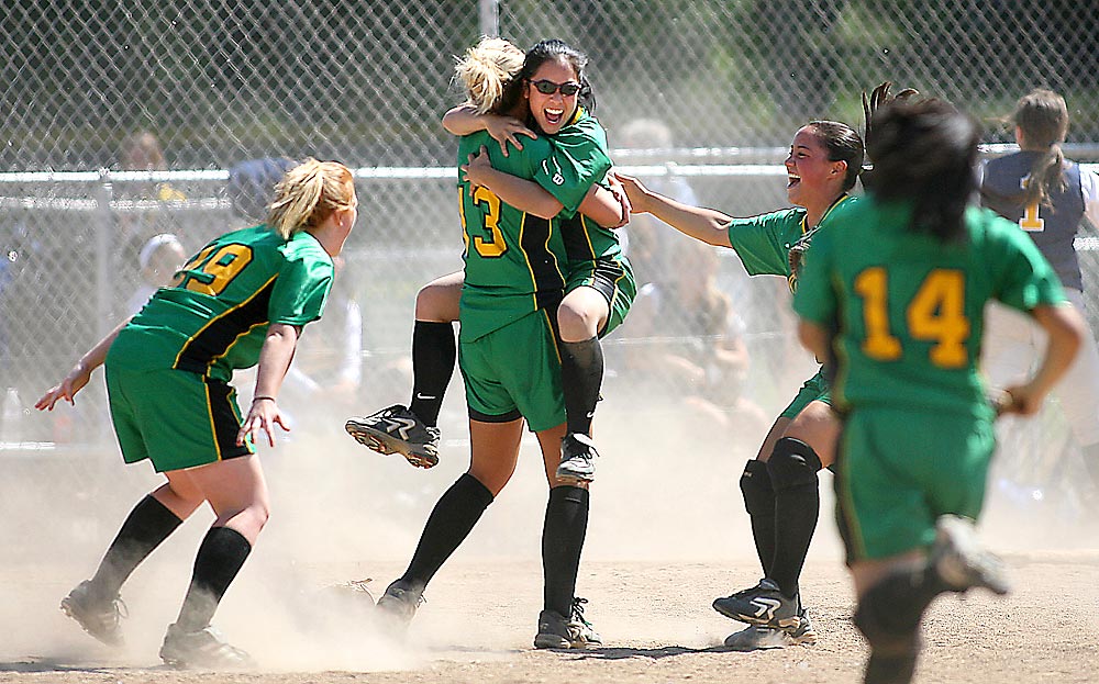 Blanchet's Adrianne Loyola jumps into the arms of pitcher Aly Schoonover following their victory over Bellevue in the 3A Sea-King District fastpitch playoffs. (Photographer: Scott Eklund)
