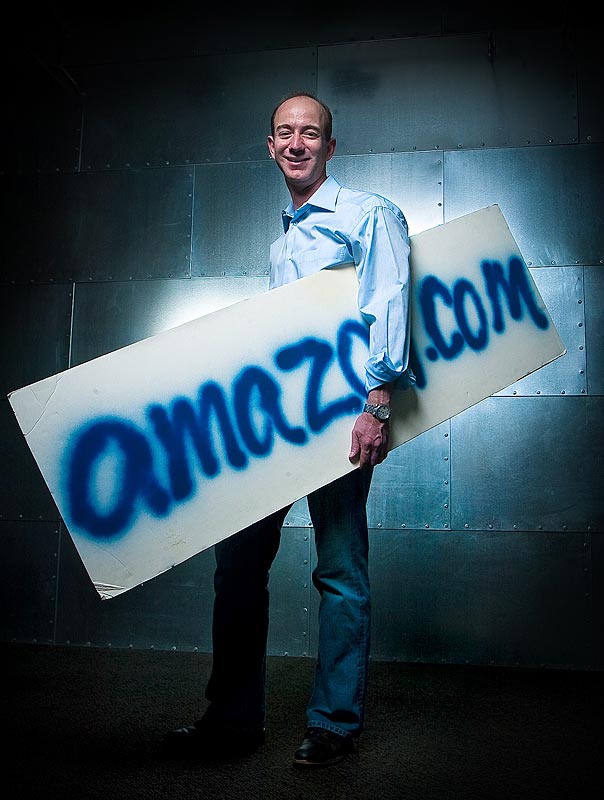 Jeff Bezos, founder of Amazon.com, holds the company's very first sign, quickly spray-painted prior to an interview with a Japanese television station in 1995. (Photographer: Andy Rogers)