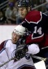 Colorado's Mike Keane takes a hit to the face from Vancouver's Scott Lachance. (Photographer: Andy Rogers)